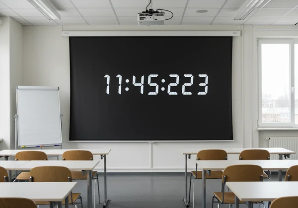 Full-screen digital clock in a modern conference room